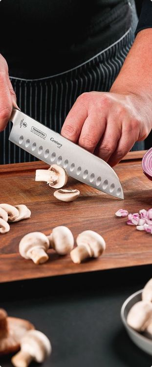 Tramontina knife cutting mushrooms on a cutting board.